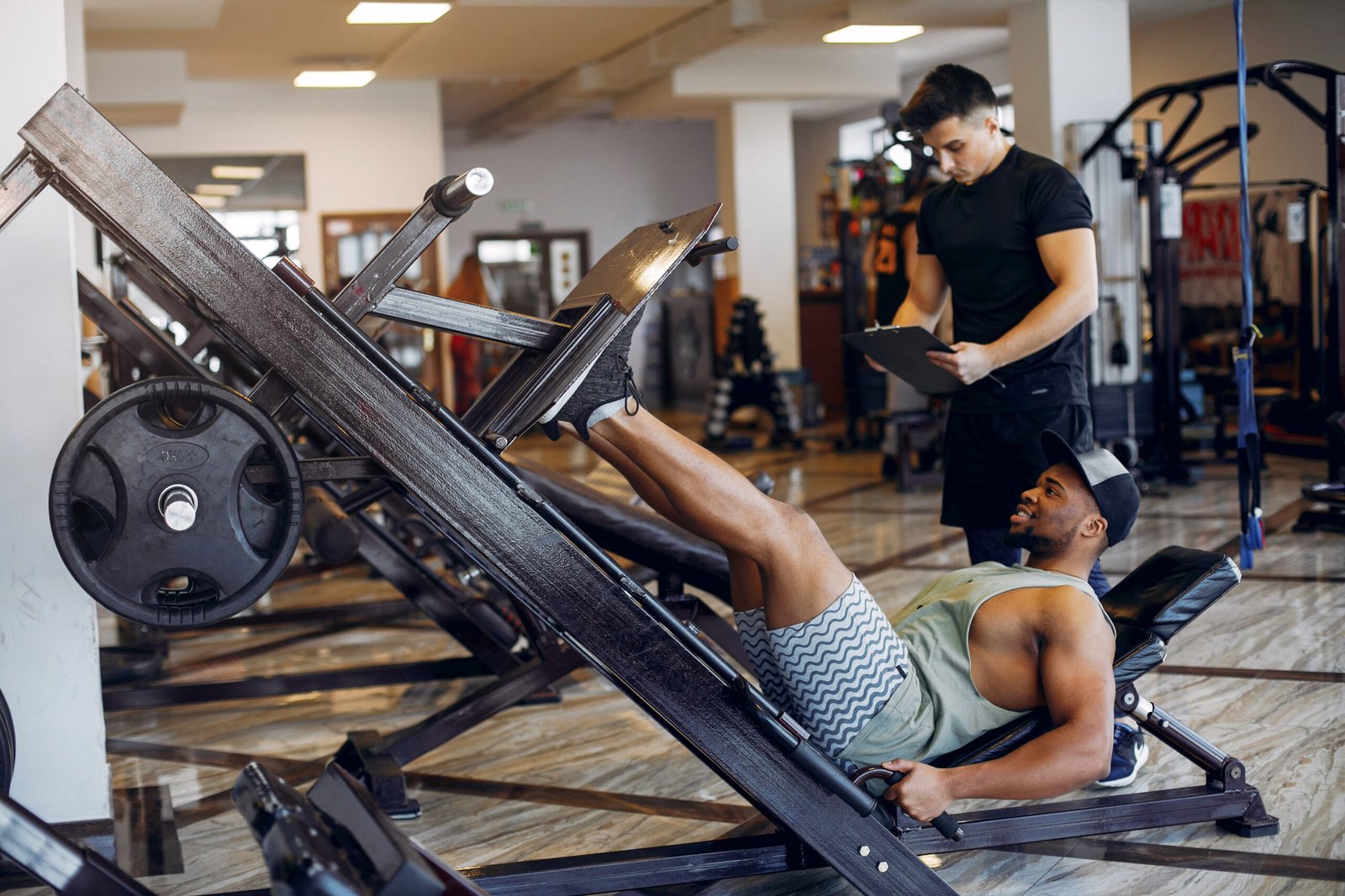 Sports men in the gym. A man performs exercises. Guy in a black t-shirt
